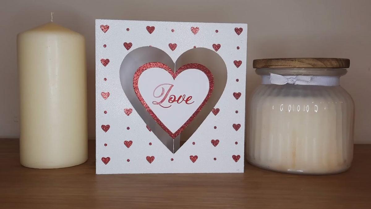 The Spinning Heart Card made with Sticky Roll, glitter and vinyl. Stood in between two candles