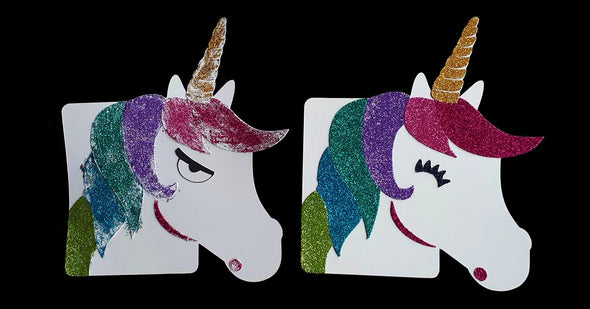Two unicorns, one decorated badly with glitter and looking grumpy, the other unicorn decorated beautifully in glitter and looking happy
