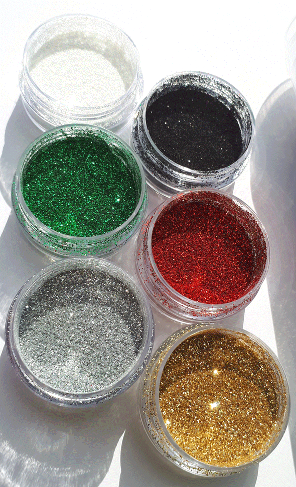 6 glitter pots in traditional Christmas colours glinting in the sun.